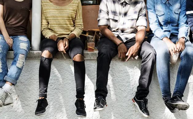 Children sitting together on a low wall